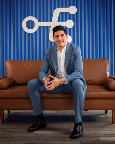 Carwin Martinez sentado en un sofá de cuero en la oficina de Ecomfy Lead, Miami