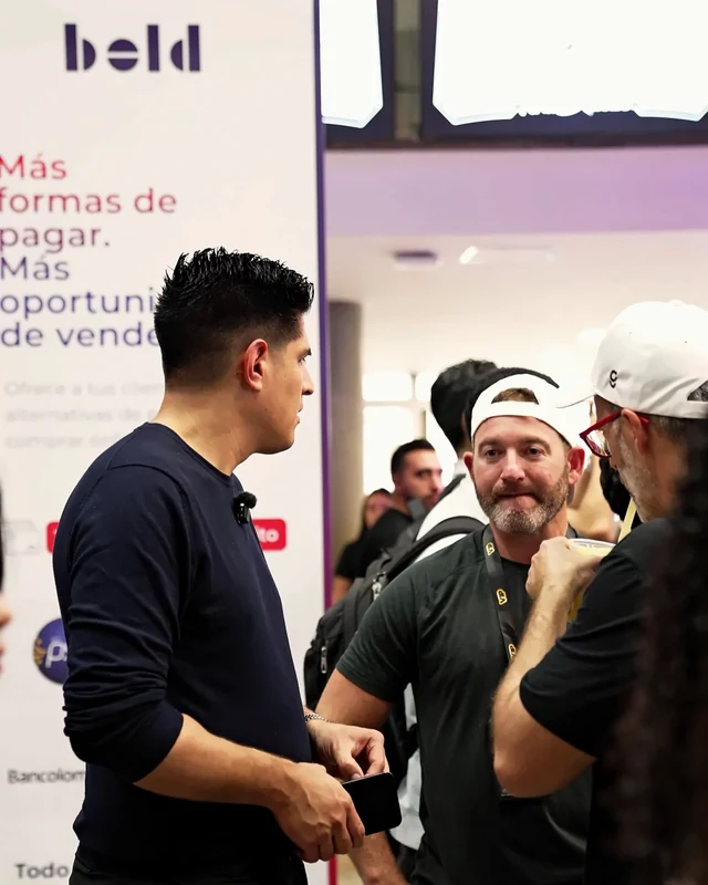 Carwin Martinez conversando con asistentes junto al banner bold en Feria Effix 2026